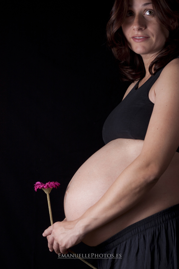 fotografía de embarazada con una flor en la mano