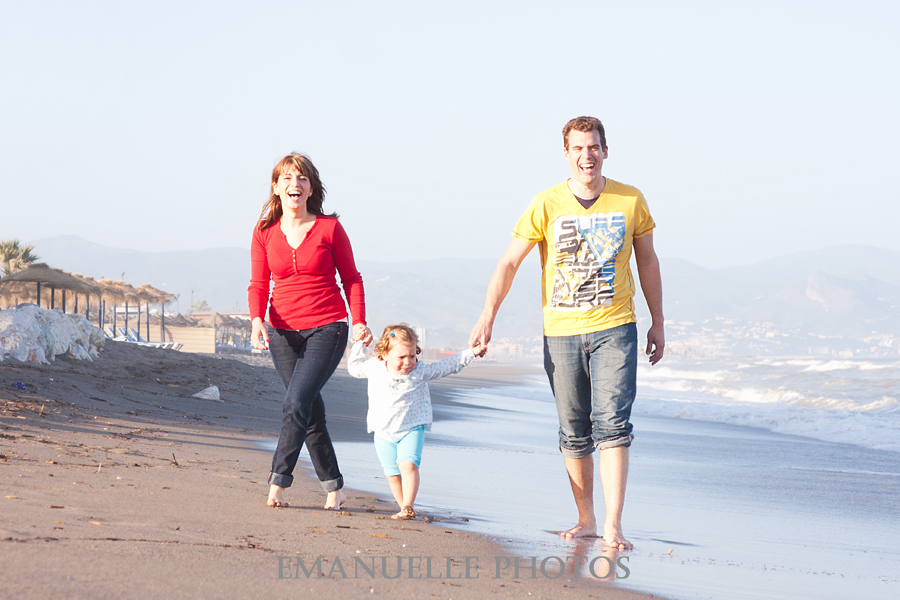 Foto de familia paseando por la playa para book de niños album